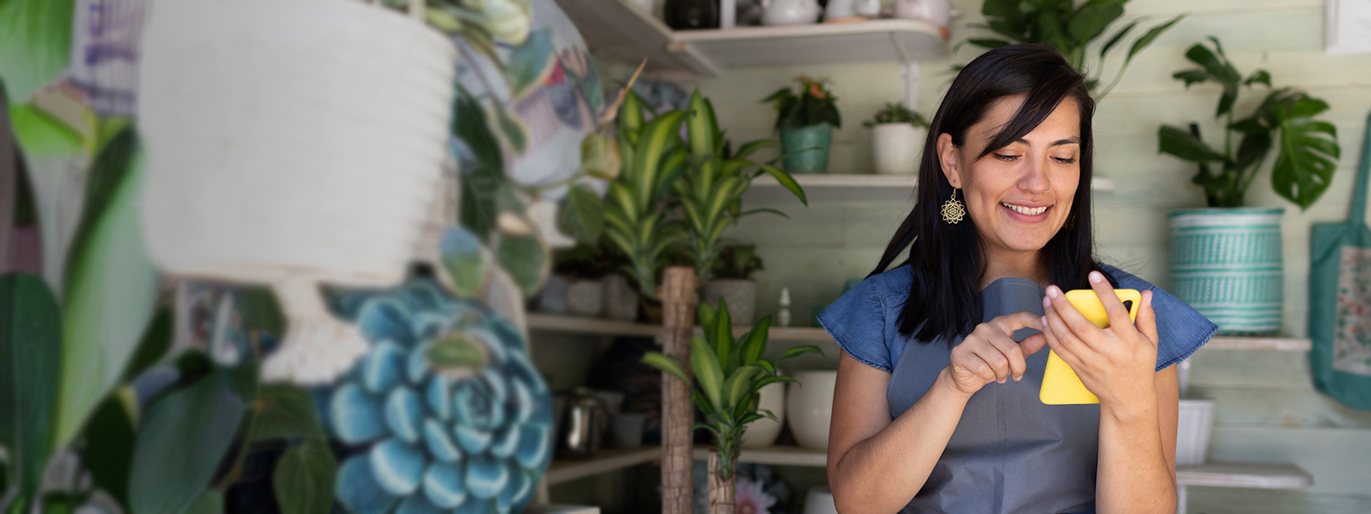 Woman using cell phone in gardening store