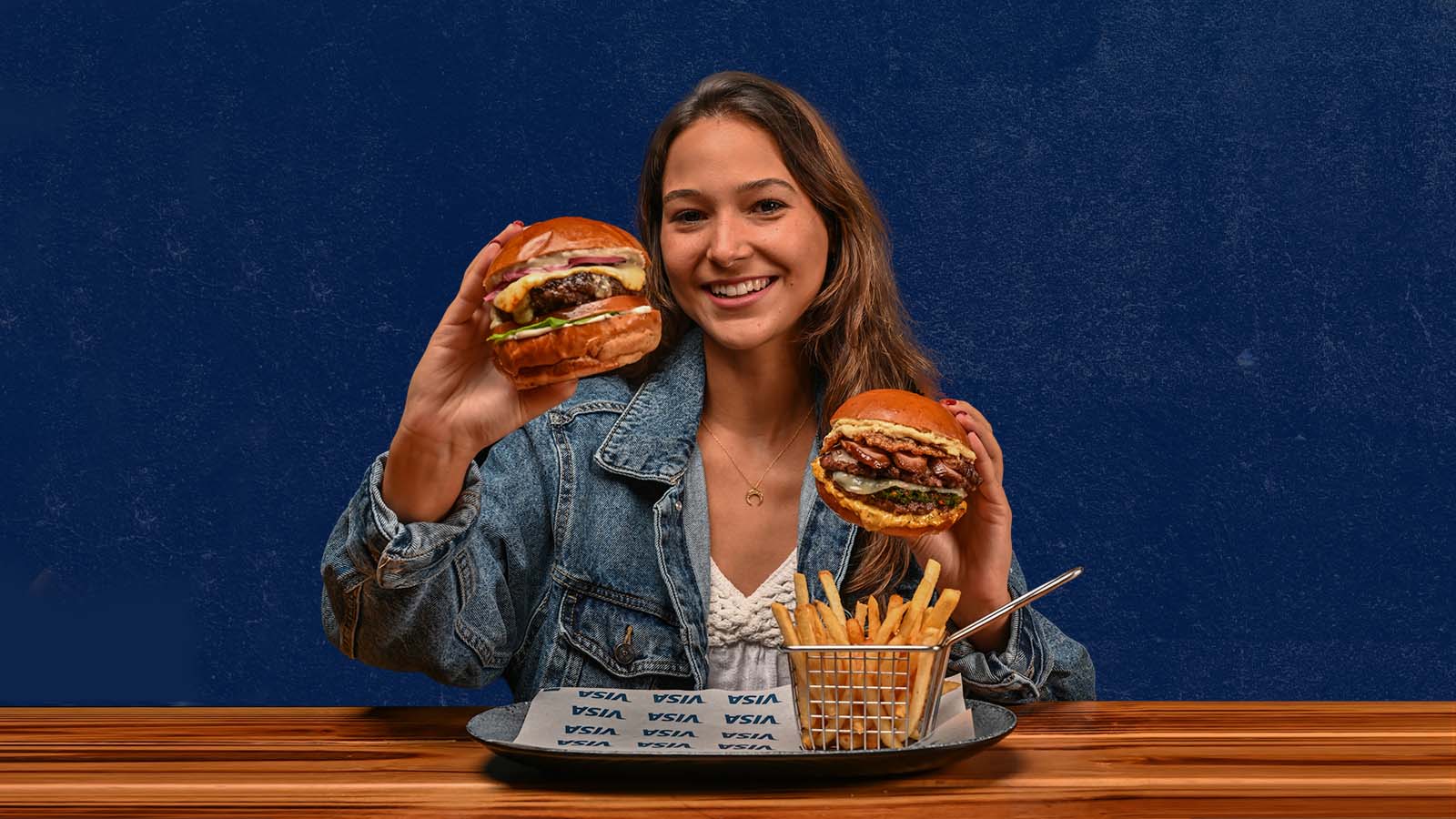 mujer sosteniendo dos hamburguesas