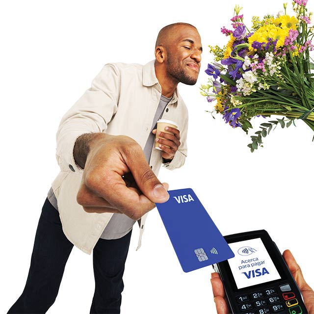 Hombre oliendo flores mientras realiza un pago contactless con tarjeta Visa