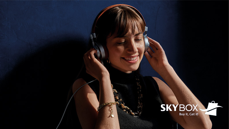 Mujer escuchando música + logo Skybox
